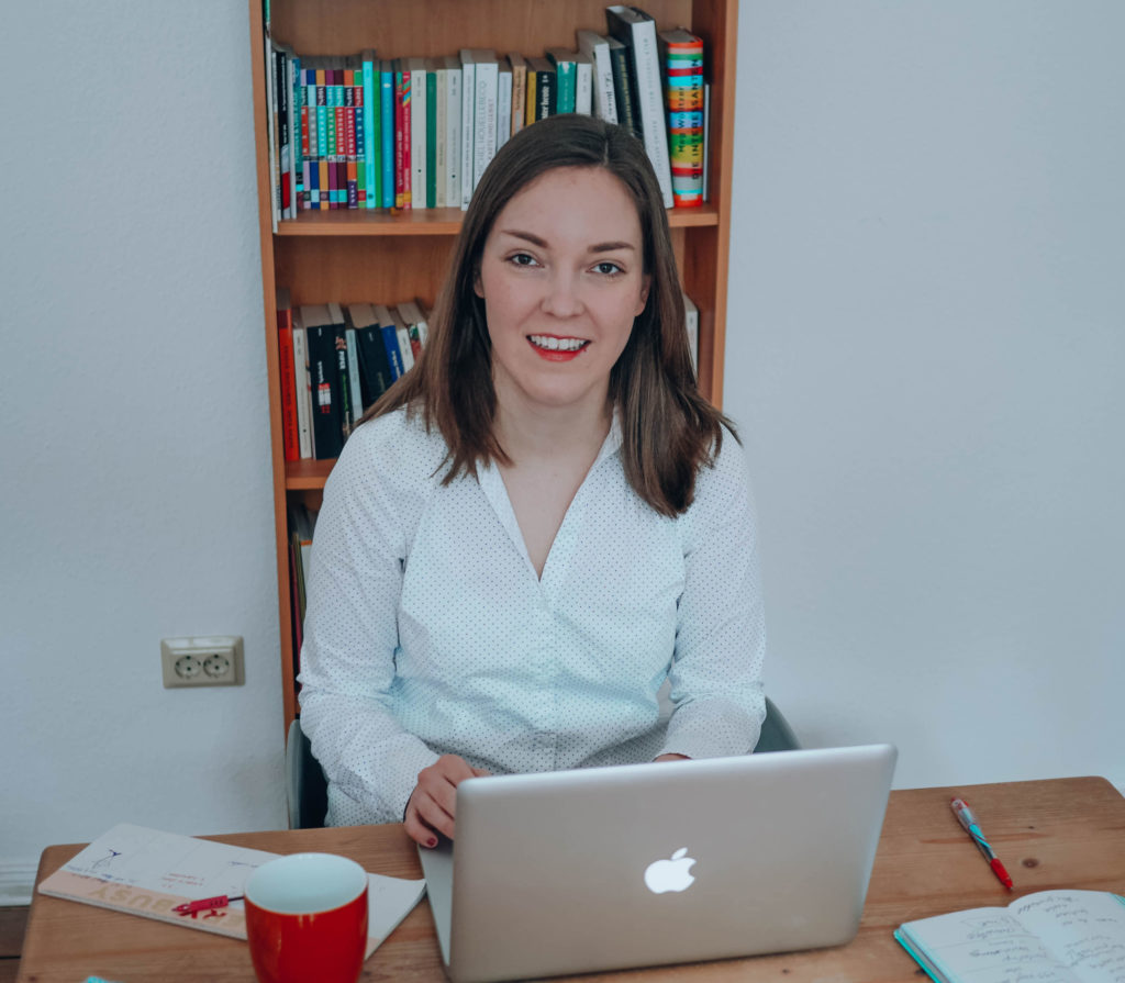 Frau mit Laptop an Holzschreibtisch